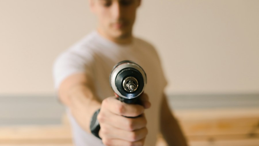 builder holding lightweight power drill overhead