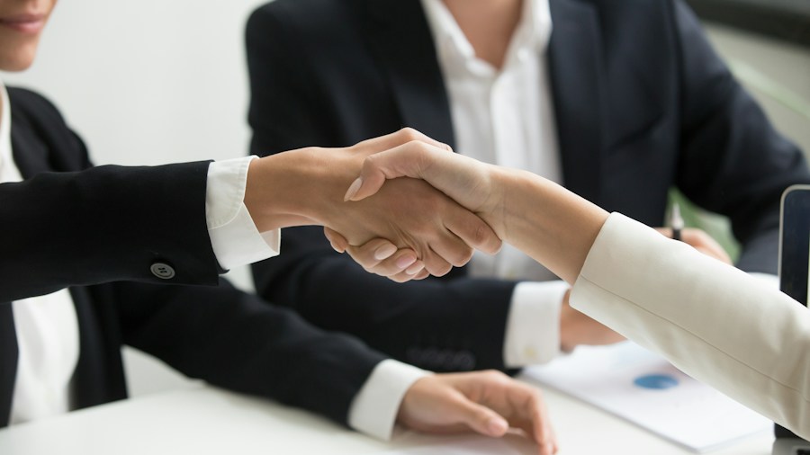 GM Scores Major Defense Contract While Ford Lags Behind: What Car Buyers Should Know 2 business partnership handshake meeting