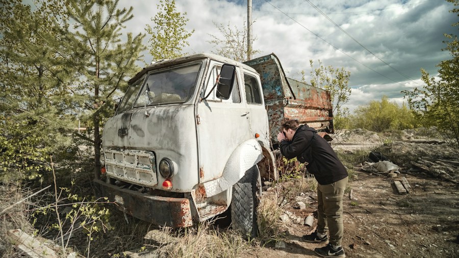 Massive Vintage Truck Auction Exposes Rust and Corrosion Risks for Restoration Buyers 2 mechanic inspecting rusty truck frame